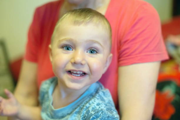 istock A little smiling boy, 1,5 years old, sits on the woman's lap. 1024130212