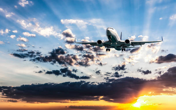istock Passenger airplane flying in the blue sky with multicolored clouds at sunset 1024139152