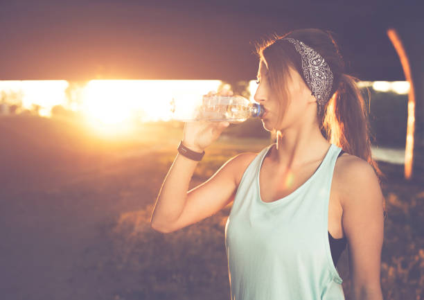 istock Woman drinking water after hard workout on beautiful sunset. 1024153230