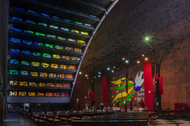 Abidjan, Ivory Coast / Côte d'Ivoire: Saint Paul's Roman Catholic cathedral, Archdiocese of Abidjan - architect Aldo Spirito - seats of the amphiteater and stained glass panel displaying the arrival of missionaries in Africa - Plateau district - 'Cathédrale Saint-Paul d'Abidjan'