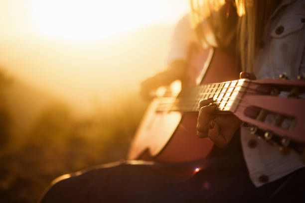 istock The Women İs Playing Guitar At The Sunset 1024167116