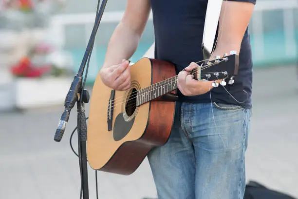 Photo of Anonymous man playing guitar on the street, street musician