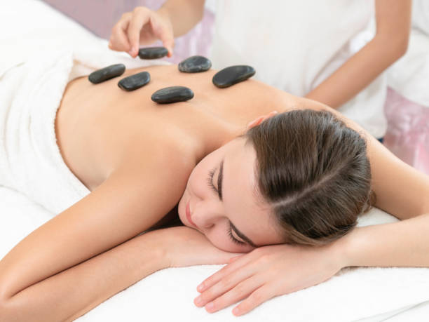 istock Hot stone massage treatment by therapist in spa. 1024173668