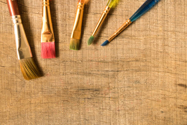 istock Different paint brushes on the old wooden table . The view from the top. Creative concept 1024178278