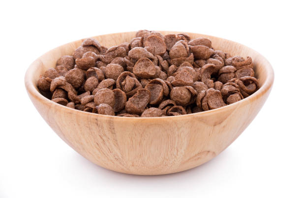 istock chocolate cereals in wooden bowl on white background. Cornflakes 1024178656