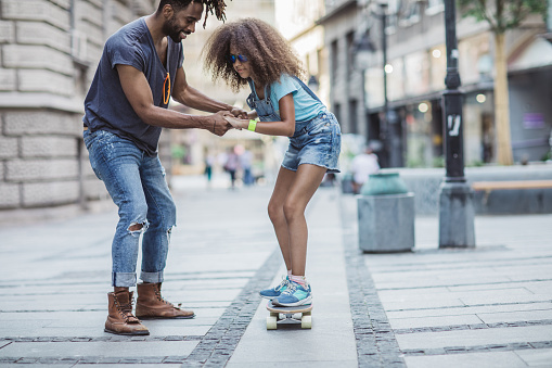 Portrait of young couple with skateboard and longboard having fun outdoors. Man and woman boyfriend and girlfriend skaters enjoying free time skating and weekend activities.