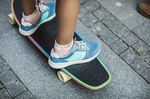 Crop shot of girls feet riding longboard.