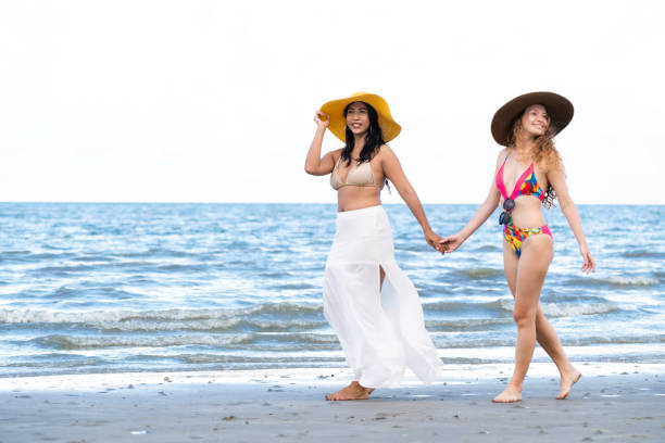 istock Happy women go sunbathing at sand beach in summer. 1024183644