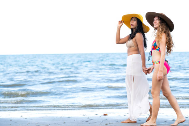 istock Happy women go sunbathing at sand beach in summer. 1024183734