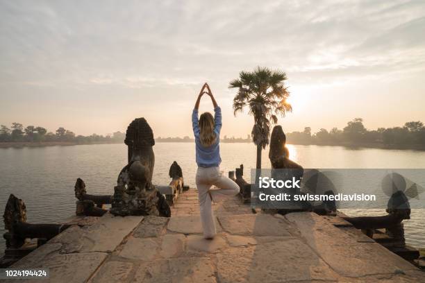 Young Woman Exercising Yoga In Ancient Temple Near Majestic Terrace Lake At Sunrise Concept Of People With Healthy Lifestyles And Wellbeing And Travel Stock Photo - Download Image Now