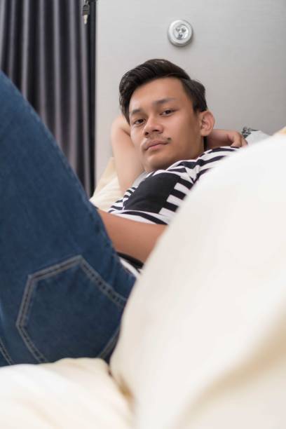 istock Relaxed casual man using a smart phone lying on the bed at home 1024202410