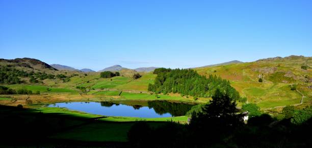 flat calm on watendlath tarn - watendlath imagens e fotografias de stock