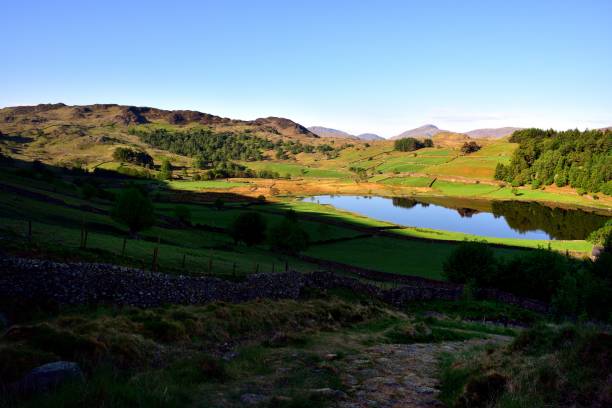 flat calm on watendlath tarn - watendlath imagens e fotografias de stock