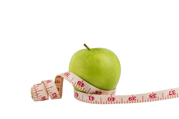 istock Isolate green apple on white bakcground with Measuring tape around. 1024206040