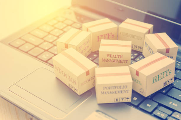 istock Online portfolio and wealth management with risk diversification concept : Paper boxes of financial instruments i.e ETFs, REITs, stocks, bonds, mutual funds, commodities, on a black laptop keyboard. 1024219786