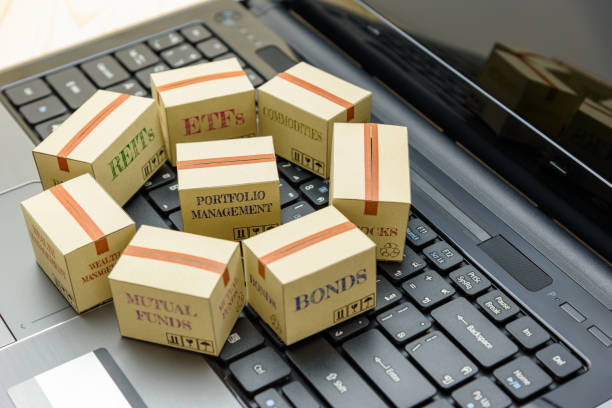istock Online portfolio and wealth management with risk diversification concept : Paper boxes of financial instruments i.e ETFs, REITs, stocks, bonds, mutual funds, commodities, on a black laptop keyboard. 1024219836