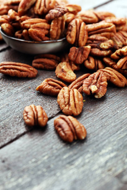 istock Pecan nuts on a rustic wooden table and pecan nuts in bowl 1024220568