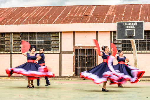 San Juan del Obispo, Guatemala -  August 3, 2018: Costa Rican folk dancers with motion blur perform in basketball court in village near UNESCO World Heritage Site of Antigua.