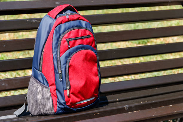 istock Backpack on wooden bench in city park 1024227350