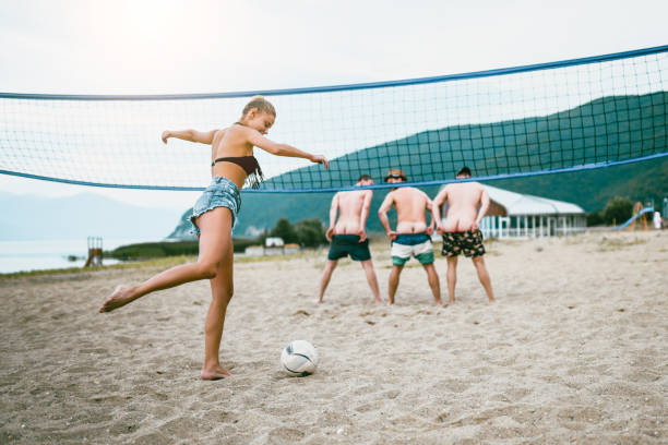 istock Cute Female Playing Beach Soccer With Friends 1024256482