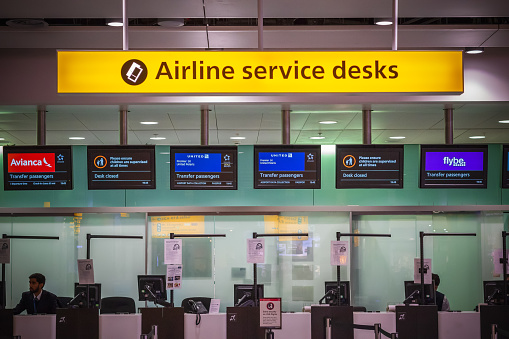 London, UK - August 12, 2018 - Staff working at airline services desks for transfer passengers at departure hall of London Heathrow Airport