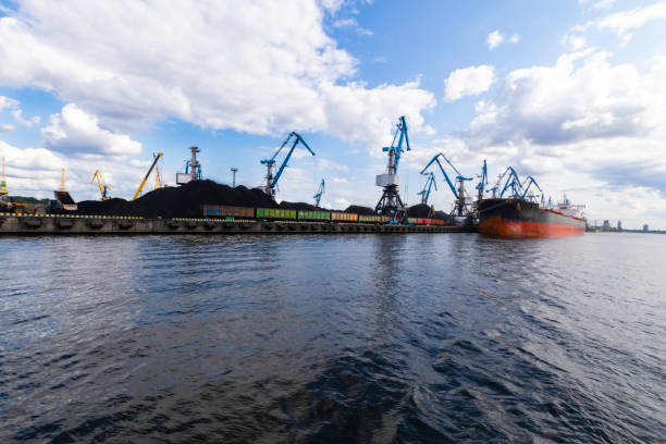 istock Large red cargo ship loading with a coal in the port, crane work in coal handling terminal 1024277198