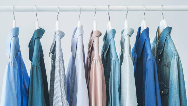 istock Assorted blue shirts hanging on wooden hangers 1024294188