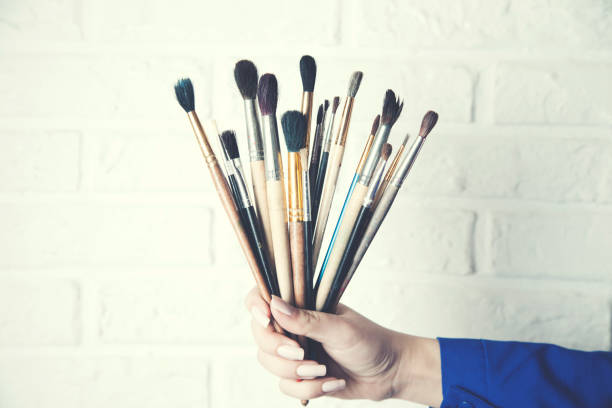 istock Womn hand brushes on brick wall background 1024299450