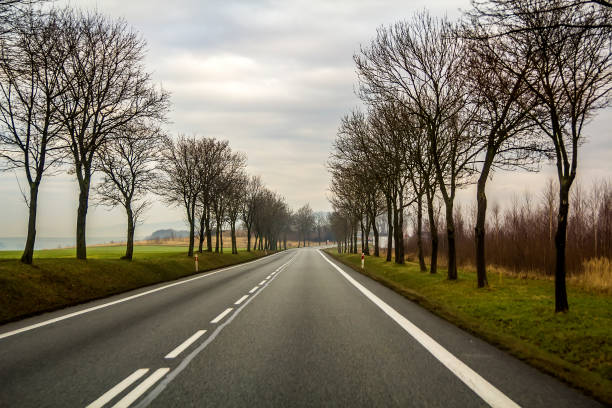 istock Curved Two Lane Country Road Winding Through Trees. 1024311220