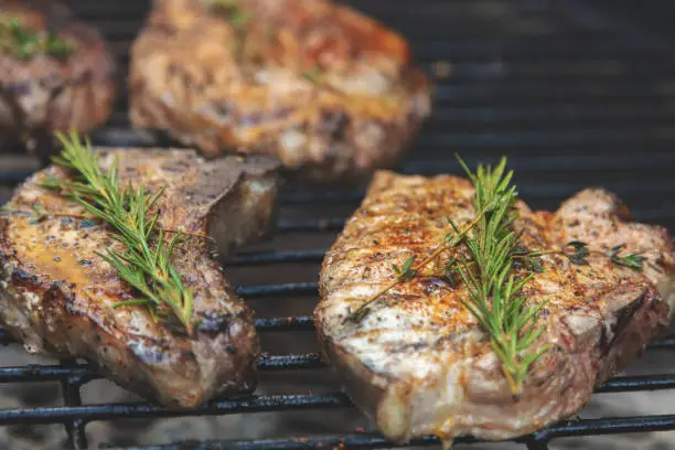 Outdoor Barbecue Grill Grilled Pork Chops with Spices and Herbs in Western Colorado - shallow DOF with various angles and DOF some with and without smoke (photos professionally retouched and filters applied as needed - Lightroom / Photoshop - original size 8688 x 5792 canon 5DS Full Frame) iStock Portfolio: http://bit.ly/eyecrave_istock Getty Images Portfolio: http://bit.ly/eyecrave_getty