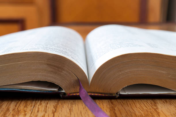 istock Open book Holy Bible on yellow wooden background 1024328462