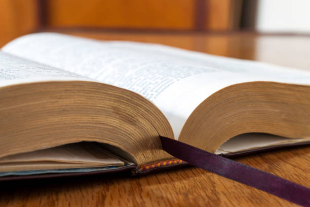 istock Open book Holy Bible on yellow wooden background 1024328502