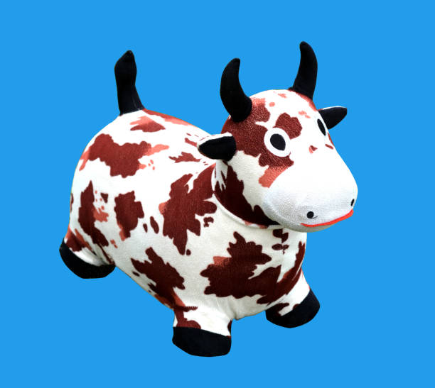 istock Toy dairy cow isolated on blue background 1024366862