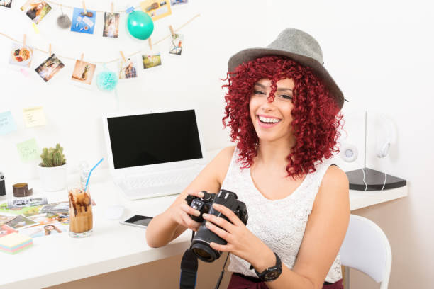 Moderno joven fotógrafo mujer alegre en oficina en casa - foto de stock