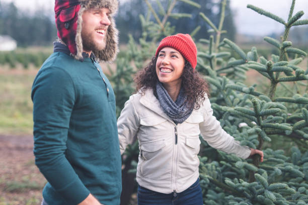 istock Young couple looking for a Christmas tree on a farm 1024484082