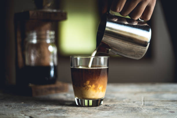 istock Black coffee in glass And milk is pouring 1024506692