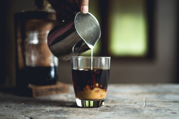 istock Black coffee in glass And milk is pouring 1024506734