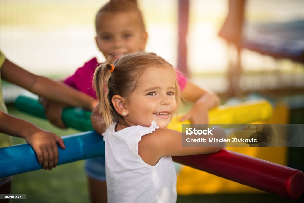 It's always important to have someone close to you. It's always important to have someone close to you. Three little girls playing in playground. Space for copy. Focus in foreground. Child Stock Photo