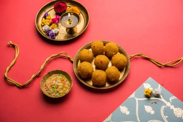 Raksha bandhan Festival : conceptual Rakhi made using plate full of Bundi Laddu sweet with band and Pooja Thali. A traditional Indian wrist band which is a symbol of love between Brothers and Sisters