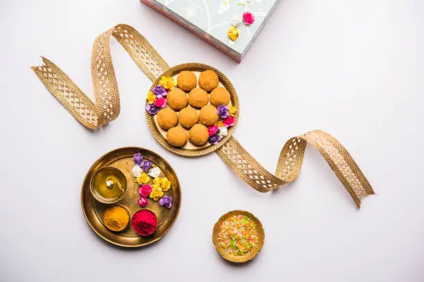 Raksha bandhan Festival : conceptual Rakhi made using plate full of Bundi Laddu sweet with band and Pooja Thali. A traditional Indian wrist band which is a symbol of love between Brothers and Sisters