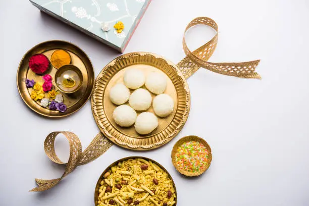 Raksha bandhan Festival : conceptual Rakhi made using plate full of Rasgulla sweet with band. A traditional Indian wrist band which is a symbol of love between Brothers and Sisters