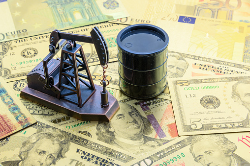 Concepto de petróleo, petrodólar y petróleo crudo: la bomba jack y un barril negro en notas de dólar estadounidense USD, representa el dinero recibido o ganado de ventas después de inversión en el desarrollo de la industria petrolera. photo