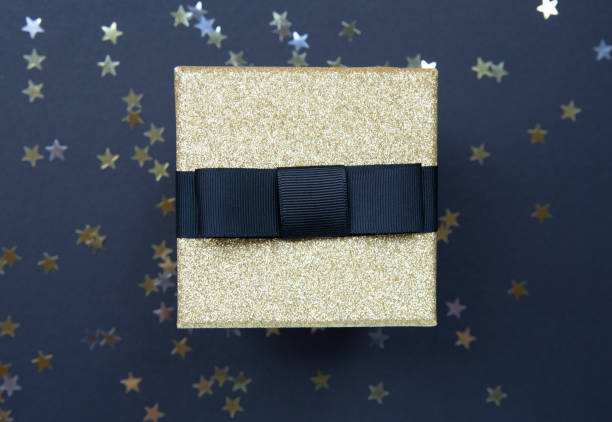 istock Christmas pattern gift box red and gold on a dark  background, decorated with a textured bow, creating a romantic atmosphere. Typically used for birthday, anniversary presents, gift cards, post cards. 1024549240
