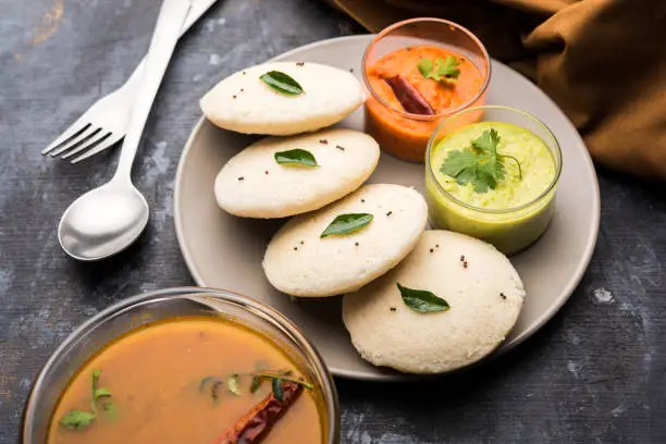 Photo of Idly sambar or Idli with Sambhar and green, red chutney. Popular South indian breakfast