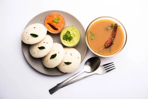 Photo of Idly sambar or Idli with Sambhar and green, red chutney. Popular South indian breakfast