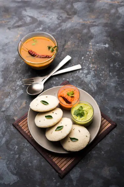 Photo of Idly sambar or Idli with Sambhar and green, red chutney. Popular South indian breakfast