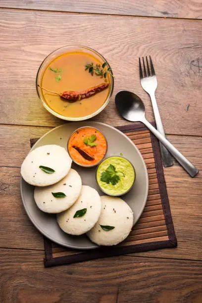 Photo of Idly sambar or Idli with Sambhar and green, red chutney. Popular South indian breakfast