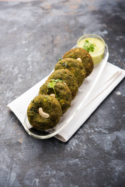 Hara bhara Kabab or Kebab is Indian vegetarian snack recipe served with green mint chutney over moody background. selective focus stock photo