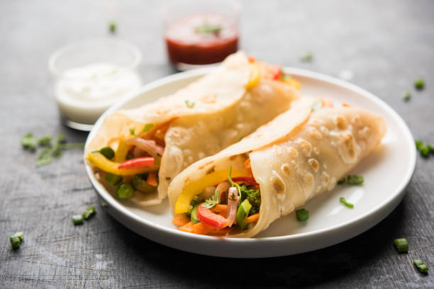 indian veg chapati wrap / kathi roll, podawane w talerzu z sosem na nastrojowym tle. selektywne skupienie - kati zdjęcia i obrazy z banku zdjęć