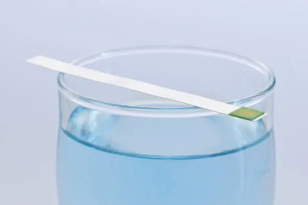 Concept idea with glass of water and test or indicator of water hardness